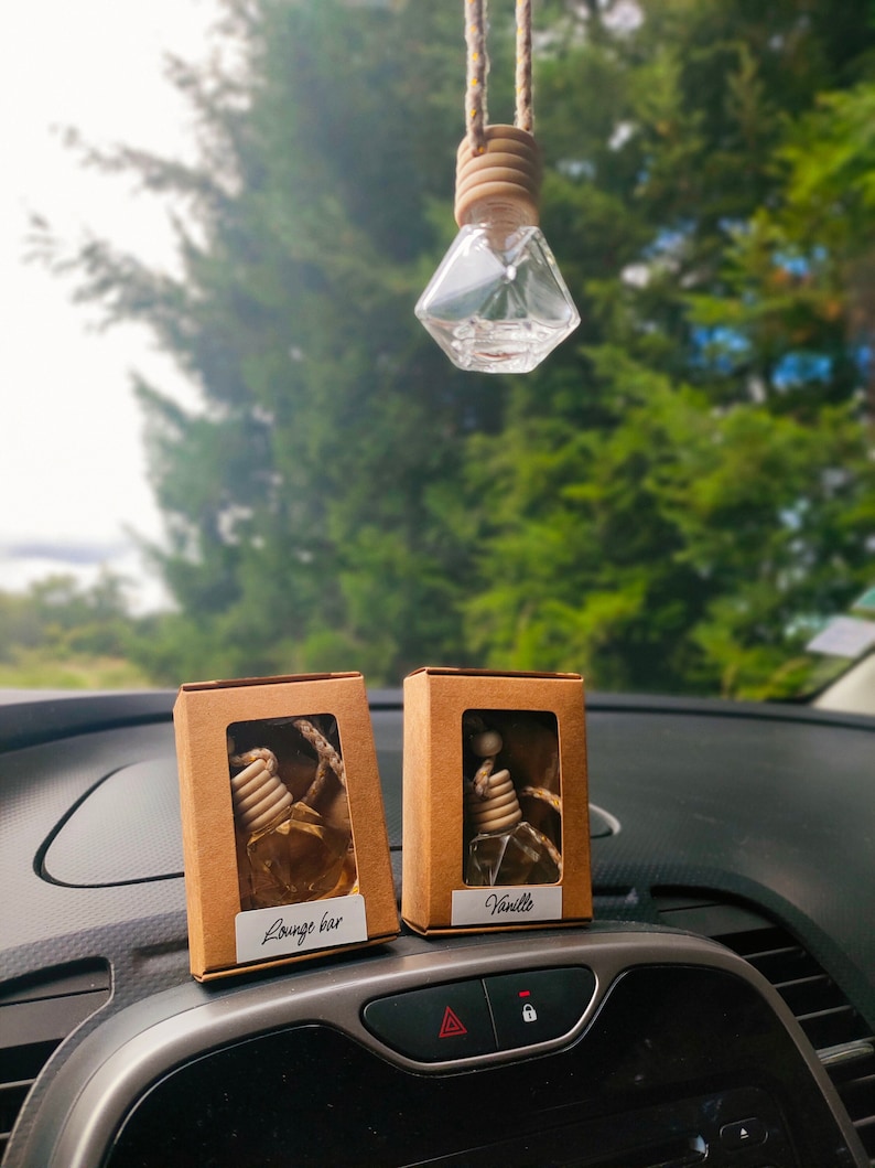 May include: Two small cardboard boxes containing car air fresheners. The boxes are brown with white text. The left box says "Lounge bar" and the right box says "Vanilla".