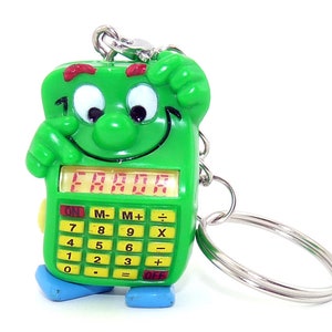 Könnte beinhalten: Grüner Taschenrechner-Schlüsselanhänger mit einem Comic-Gesicht und dem Wort "ERROR" auf dem Bildschirm. Der Rechner hat ein Ziffernblatt mit Tasten für Addition, Subtraktion, Multiplikation und Division.