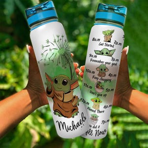 May include: A white water bottle with a blue lid and a green and brown cartoon character on the front. The bottle has a motivational quote on the side with the text "Get Started", "Remember your goal", "Keep chugging", "Don't give up", "Almost There", "You did it", and "All Now". The name "Michael" is written on the bottom of the bottle.