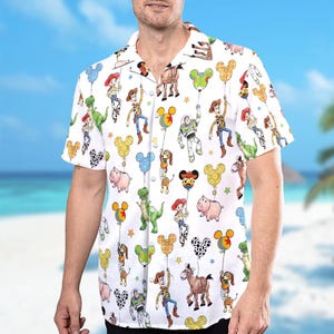 Puede incluir: Camisa blanca de manga corta con un estampado colorido de personajes de dibujos animados y globos con forma de Mickey Mouse. La camisa tiene un cuello cl&aacute;sico. El dise&ntilde;o incluye personajes como Woody, Buzz Lightyear y otros de la franquicia Toy Story.