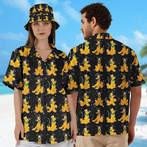 May include: Two short-sleeved button-up shirts with a black background and a repeating pattern of yellow cartoon dogs. The shirts have a collared neckline and a button-up front.