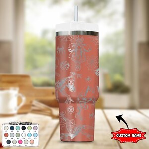 May include: A coral-colored tumbler with a white lid and straw, featuring a silver Spider-Man pattern. The design includes Spider-Man figures, spiderwebs, and the Spider-Man logo. The tumbler has a "Custom Name" label.
