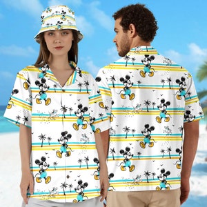 May include: Two white short-sleeved shirts with a tropical print featuring Mickey Mouse, palm trees, and blue and yellow stripes.