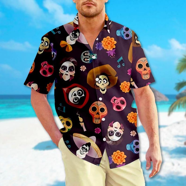 May include: A black button-up shirt with a colourful print of characters and skulls from the animated film Coco. The shirt has short sleeves and a button-up collar.