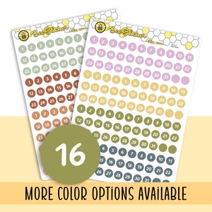May include: Two sheets of sticker paper featuring a bee logo and the text "Bee Sticker". Each sheet contains 31 round stickers with numbers 1 to 31 in white text. The stickers are in a variety of colours, including green, brown, yellow, pink, and grey.