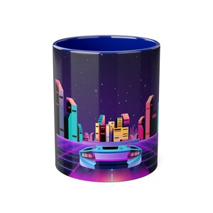May include: A blue ceramic mug with a retro-futuristic design. The mug features a cityscape with neon lights and a sports car driving through a grid pattern.