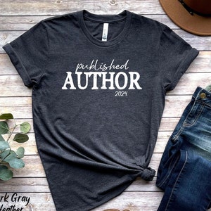 May include: Dark gray heather t-shirt with the text "published author 2024" in white.