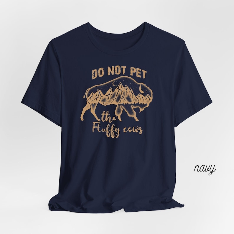 May include: Navy blue t-shirt with a brown graphic of a bison with mountains and the text "Do Not Pet the Fluffy Cows".