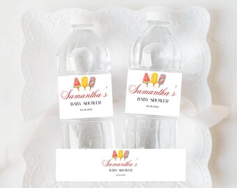 May include: Two clear plastic water bottles with white caps. Each bottle has a label with the text "Samantha's BABY SHOWER" and the date 05.26.2025. The label features watercolor illustrations of three popsicles.