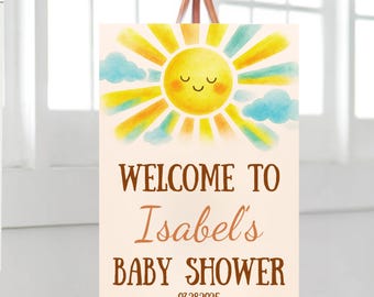 May include: Welcome to Isabel's Baby Shower sign with a watercolor illustration of a smiling sun with clouds. The date 03.28.2025 is printed below the text.
