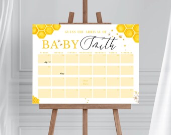 May include: A white baby shower sign with a honeycomb pattern and the text "Guess the arrival of Baby Smith". The sign has a calendar with the months of April and May, with spaces for guests to guess the baby's due date.