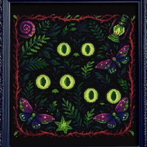 Puede incluir: Obra de arte enmarcada en negro con un diseño de punto de cruz. Muestra ojos de gato verdes brillantes, follaje verde oscuro, mariposas y una linterna. La obra está enmarcada en un marco negro ornamentado.