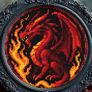 Puede incluir: Una obra de arte de punto de cruz de un dragón rojo con llamas naranjas y amarillas sobre un fondo negro. La obra está enmarcada en un marco ovalado negro y ornamentado. El dragón tiene grandes alas.