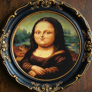 May include: A framed cross-stitch of the Mona Lisa portrait. The artwork is in a round, black frame with gold filigree accents. The background is a wooden surface.