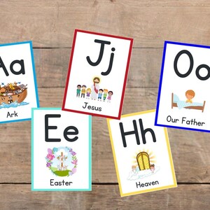 May include: Six colorful flashcards with uppercase and lowercase letters, illustrations, and words. The letters are A, E, H, J, O. The words are Ark, Easter, Heaven, Jesus, Our Father.