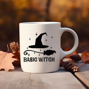 May include: White ceramic mug with a black silhouette of a witch's hat and broom, and the text "BASIC WITCH".