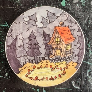 May include: A watercolor illustration of a small cottage in the woods with a mushroom ring around it. The cottage has a red roof and a chimney. The trees are dark green and the mushrooms are yellow and brown.