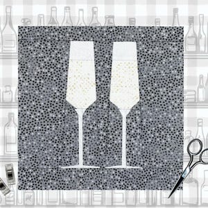 May include: Two tall, clear champagne flutes against a grey and white speckled background. The flutes are empty and have a classic design.