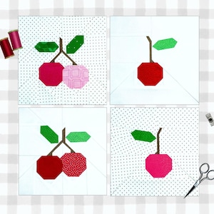 Peut inclure: Quatre carrés de tissu blanc avec un motif de cerises en patchwork. Chaque carré présente une combinaison de couleurs différente de cerises rouges, roses et vertes.