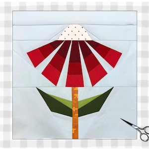 May include: A fabric flower block with a red and white flower design. The flower has a dotted white top and red petals. The stem is orange and green, with green leaves. A pair of scissors is in the lower right corner.