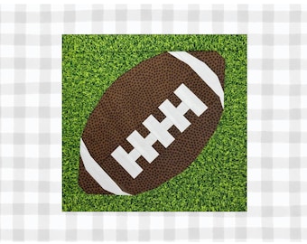 May include: A brown and white football on a green grass background. The football has white laces and a brown leather texture.
