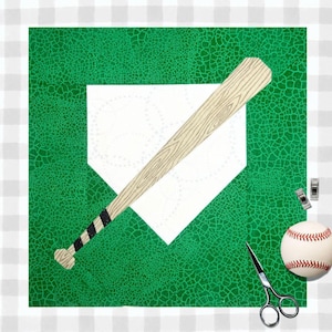 May include: A square fabric quilt block featuring a green crackle-patterned background, a white home plate shape with faint baseball stitching outlines, and a diagonal wooden baseball bat with black and white striped handle tape.