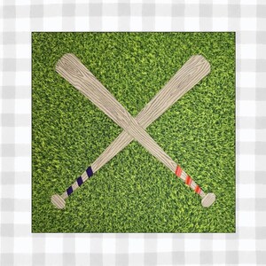 May include: Two wooden baseball bats crossed over each other on a green grassy background. The bats have blue and white stripes on one end and orange and white stripes on the other end.