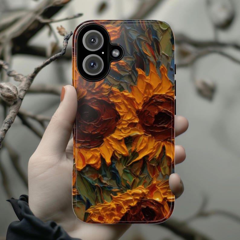 May include: A phone case with a colorful sunflower design. The case has a black background with a painting of sunflowers in shades of yellow, orange, and brown.