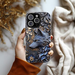 May include: A black and blue phone case with a wolf design and gold accents. The case has a camera lens cutout and a floral pattern.