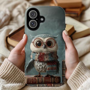 Può includere: Una custodia per telefono con un'illustrazione di gufo stravagante. Il gufo, con occhiali e sciarpa, è appollaiato su una pila di libri. La custodia ha uno sfondo grigio ed è tenuta da una persona.