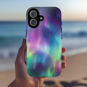 Puede incluir: Una funda para tel&eacute;fono con un dise&ntilde;o de aurora boreal colorido. La funda es negra y tiene un recorte para el objetivo de la c&aacute;mara.