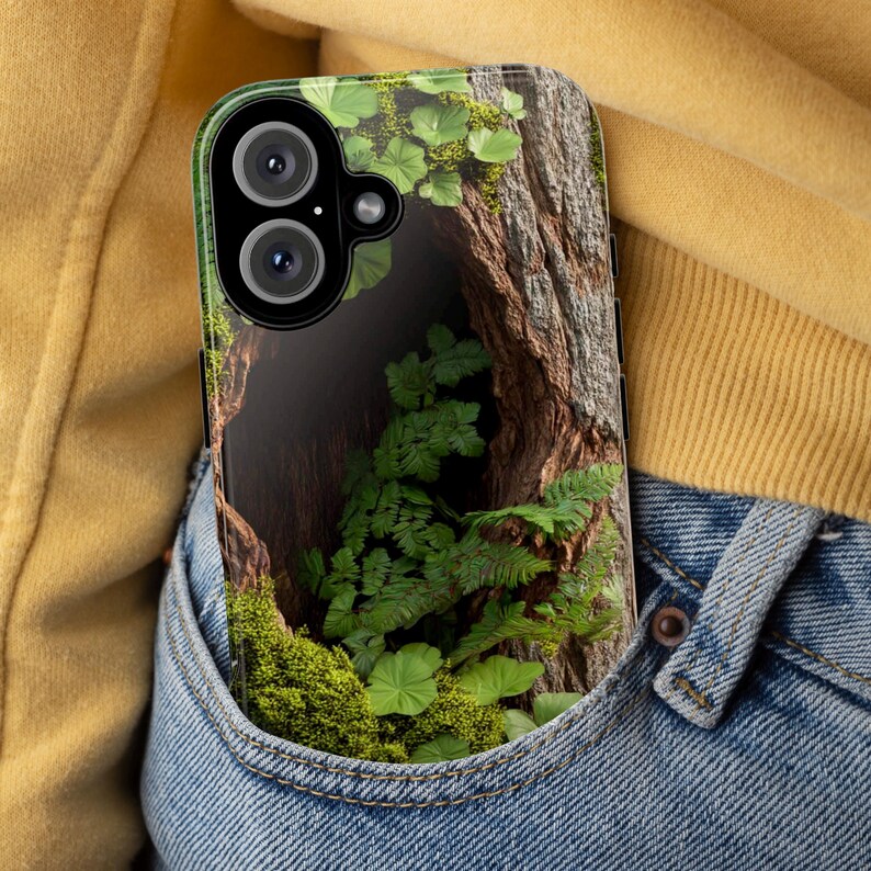 May include: A clear phone case with a design of a tree trunk, green leaves, and moss. The case is in a blue jean pocket.