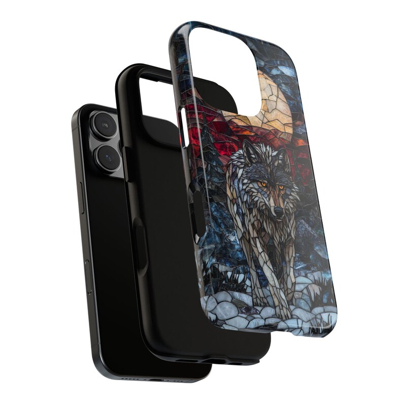 May include: A black phone case with a stained-glass style wolf design. The wolf has gray and brown fur, with yellow eyes, and is set against a backdrop of a full moon and rocky terrain. The case is shown separate from the phone.