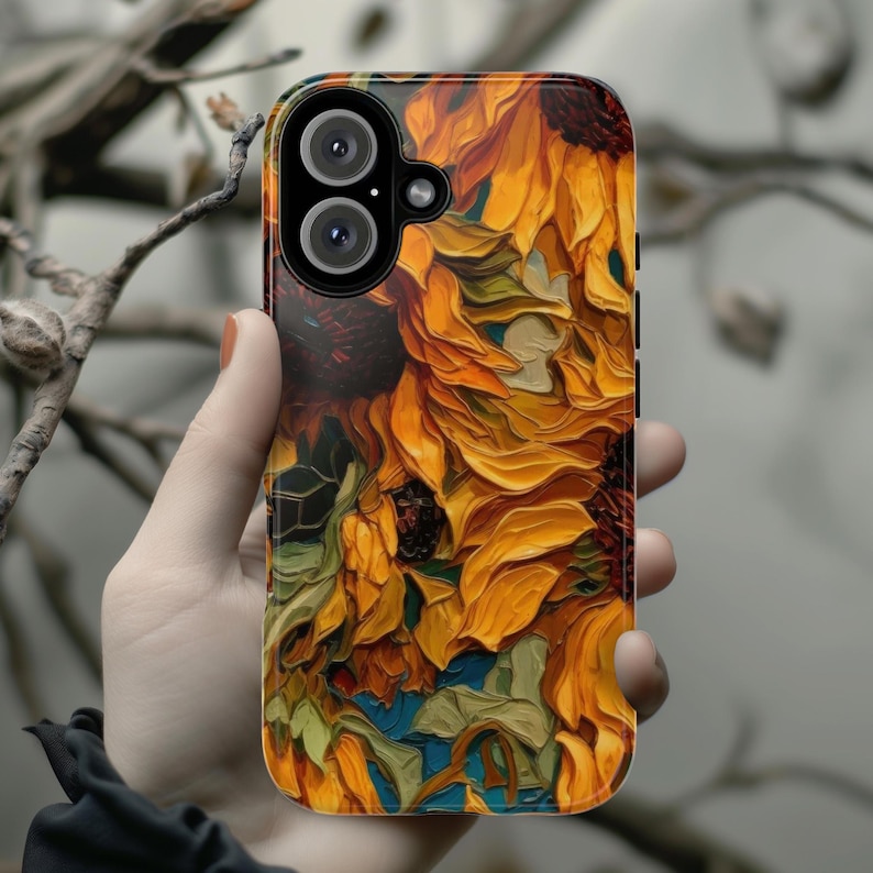 May include: A phone case with a vibrant sunflower design. The case features a close-up of sunflowers with yellow, orange, and green hues. The case has a camera cutout for a dual-lens camera.
