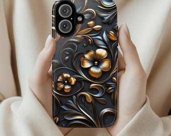 May include: A phone case with a floral pattern. The case has a dark grey base with gold and blue floral detailing. The flowers are finished in metallic gold, and the leaves and vines are a mix of gold and blue.