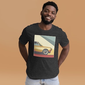 May include: A dark grey t-shirt featuring a retro-style illustration of a yellow car with a red stripe on a colourful background.