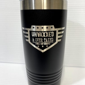 Op de afbeelding: Zwarte roestvrijstalen tumbler met een zilveren inscriptie die "Unvaxxed & Over Taxed I Will Not Comply" luidt, met vijf sterren boven en onder de tekst.