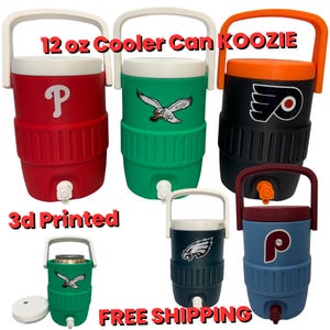 May include: A selection of 3D-printed 12 oz cooler can koozies in different colours, each with a team logo. The koozies have a white handle and a tap for dispensing drinks. The text "12 oz Cooler Can Koozie" is visible.
