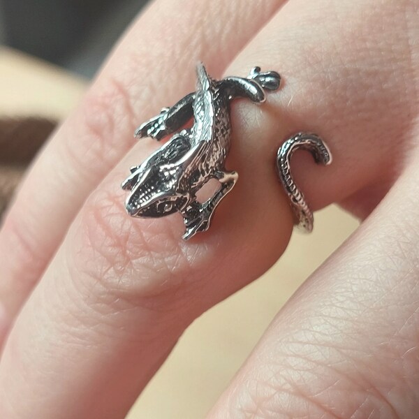 An ancient lizard ring with its tail wrapping around a finger, a bulky metal ring, a ring in the style of animalism, one size, adjustable.