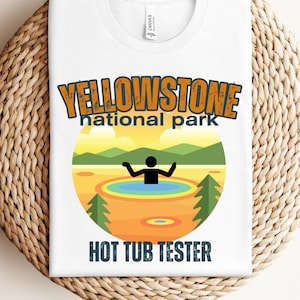 May include: White t-shirt with a graphic design of a person in a hot spring. The graphic says "Yellowstone National Park Hot Tub Tester".