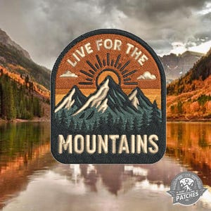 Puede incluir: Parche bordado con un diseño de montaña y sol. El parche presenta el texto "LIVE FOR THE MOUNTAINS" en letras blancas. El parche tiene un borde negro y una escena de montaña y bosque en tonos naranja, azul y verde.