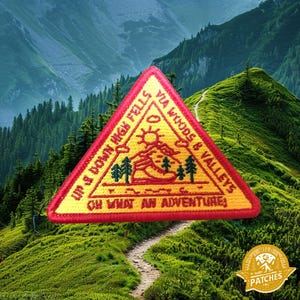 May include: A yellow and red triangular patch with the text "Up & Down High Fells Via Woods & Valleys Oh What An Adventure" and a stylised image of a hiker walking on a path.