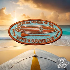 Könnte beinhalten: Orangefarbener und blauer gestickter Aufnäher mit dem Text "Official Member of the I Supped & Survived Club" und einem stilisierten Bild eines Paddleboards.