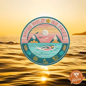 May include: A round embroidered patch with a teal border and the text "Swim Wild Be Free" in a circle. The patch features a sunset scene with mountains, a sun, and a swimmer in the ocean.
