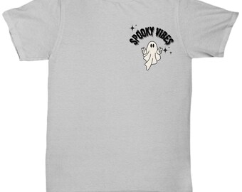 May include: A light gray t-shirt featuring a small graphic of a friendly ghost with the words "Spooky Vibes" in a black, stylized font. The ghost is white with black eyes and is giving a peace sign.