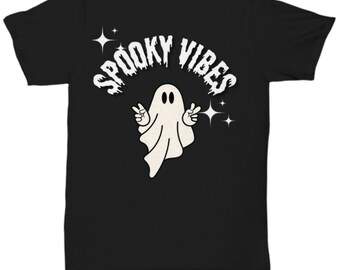 May include: Black t-shirt featuring a white ghost illustration with peace signs and the text "SPOOKY VIBES" in a retro font. The design includes star accents, creating a fun, Halloween-themed graphic.