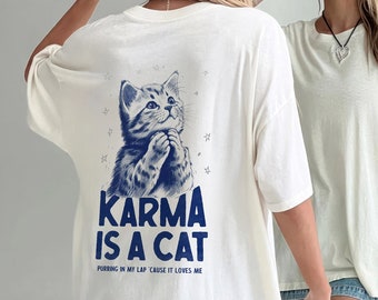 May include: White oversized t-shirt with a blue graphic of a cat and the text "KARMA IS A CAT PURRING IN MY LAP 'CAUSE IT LOVES ME".