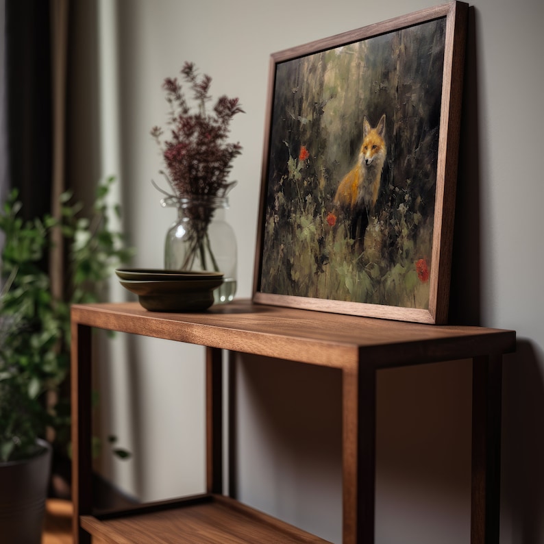 Puede incluir: Una estanter&iacute;a de madera con dos estantes, que presenta una pintura enmarcada de un zorro en un entorno de bosque. La pintura est&aacute; en un marco de madera oscura y est&aacute; sentada en el estante superior. Tambi&eacute;n hay un jarr&oacute;n con flores secas en el estante.