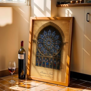 May include: A framed print of a cathedral stained glass window in a wooden frame. A bottle of red wine and a wine glass with red wine are next to the frame. The print has the text "Rosace e Nord" at the bottom.