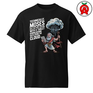 Puede incluir: Camiseta negra con una ilustración de dibujos animados de Moisés sosteniendo una tableta y un bastón, con un gráfico de nube. El texto dice: "TECHNICALLY, MOSES WAS THE FIRST PERSON WITH A TABLET DOWNLOADING DATA FROM THE CLOUD."
